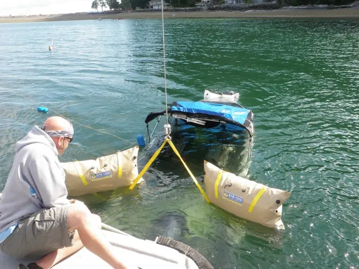 Lift bags rigged around a partially submerged small boat
