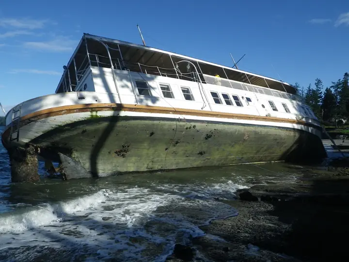 Large grounded vessel exposed at low tide